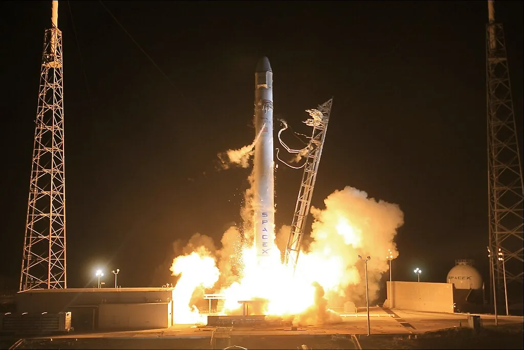 Despegue nocturno de un cohete Falcon de SpaceX entre llamas y humo