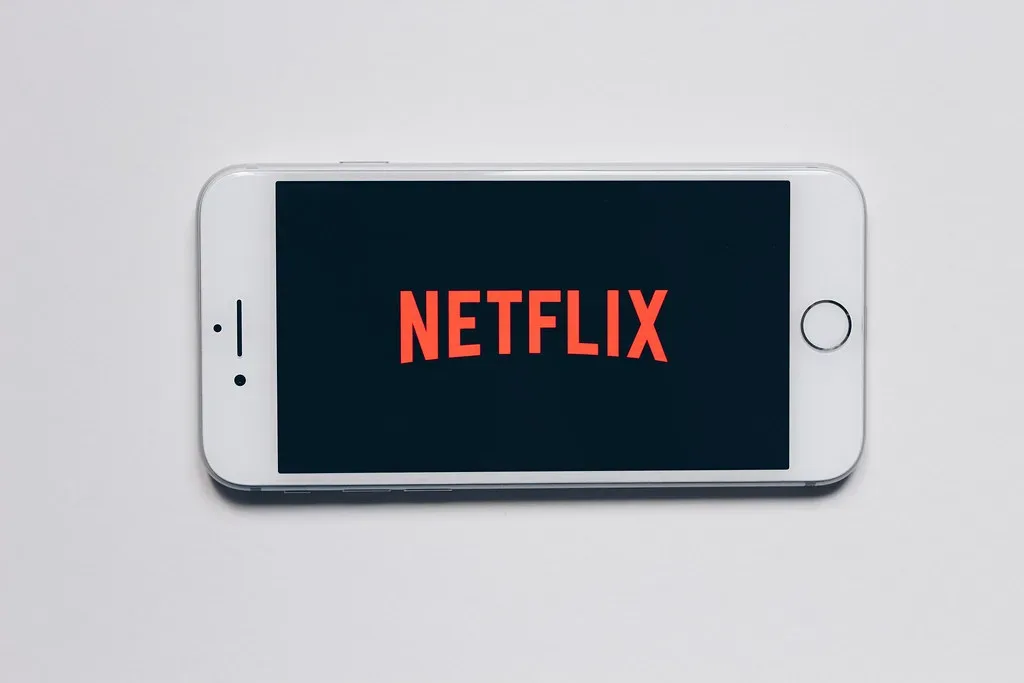 Un teléfono móvil sobre fondo blanco muestra el logo de Netflix en pantalla