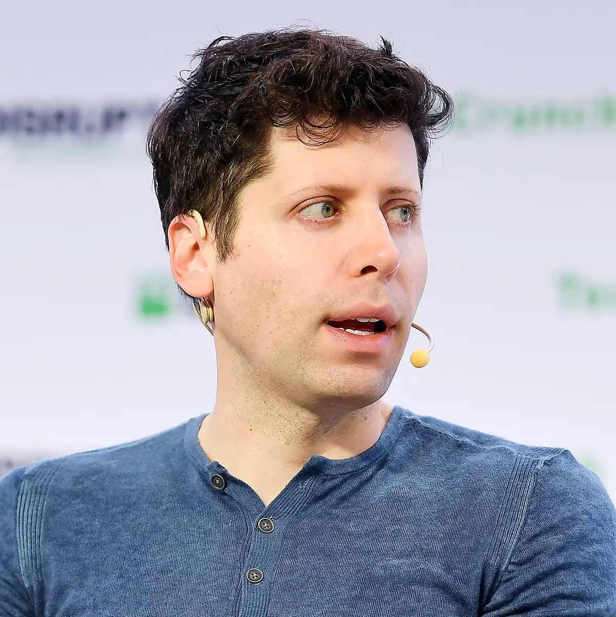 Sam Altman habla con micrófono de diadema durante una conferencia tecnológica