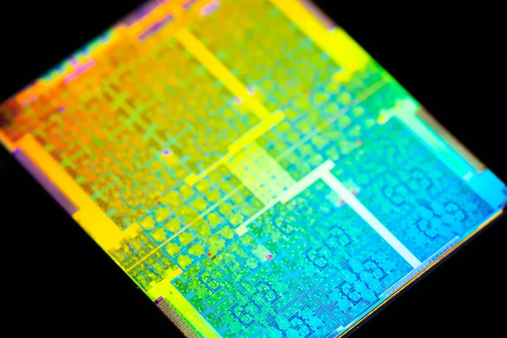 Primer plano microscópico de un chip semiconductor con colores iridiscentes.