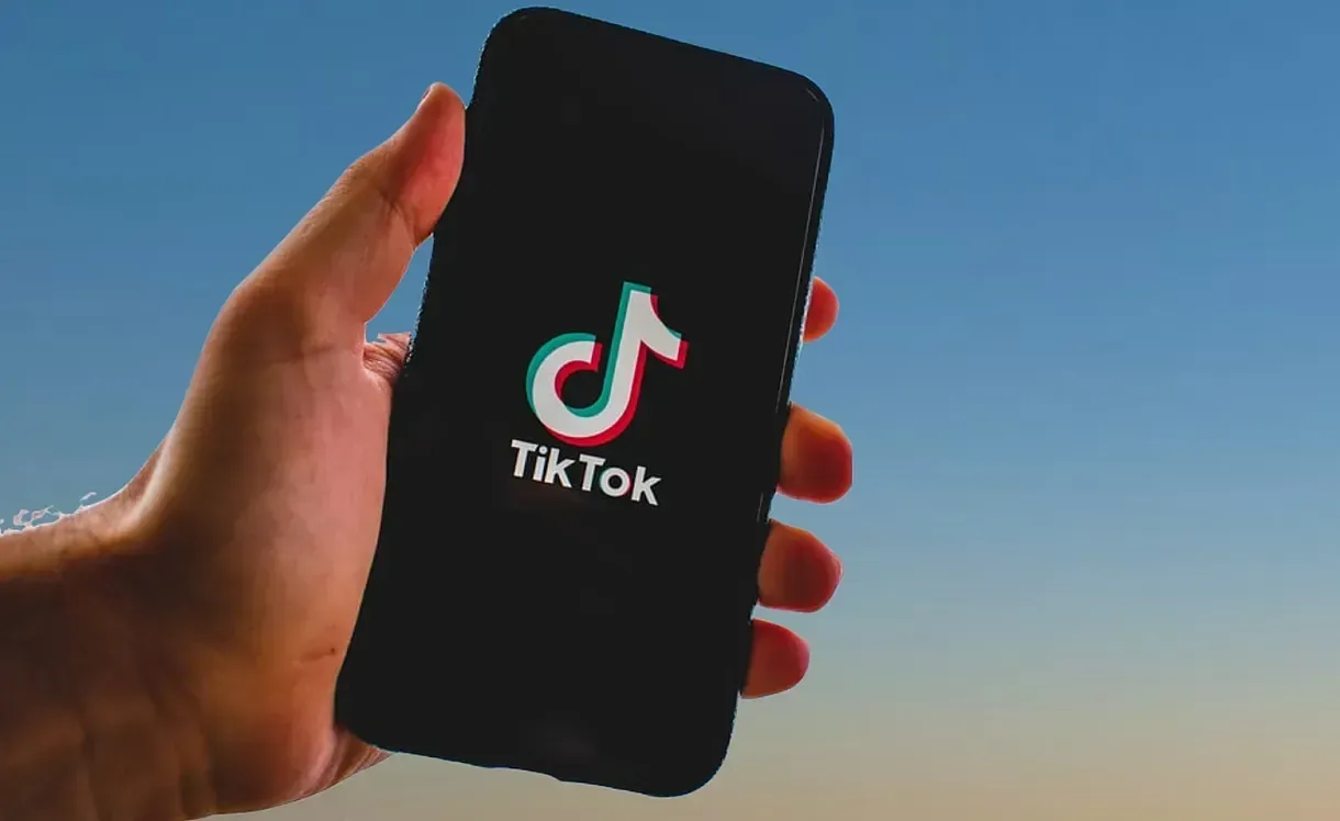 Mano cogiendo un teléfono con TikTok
