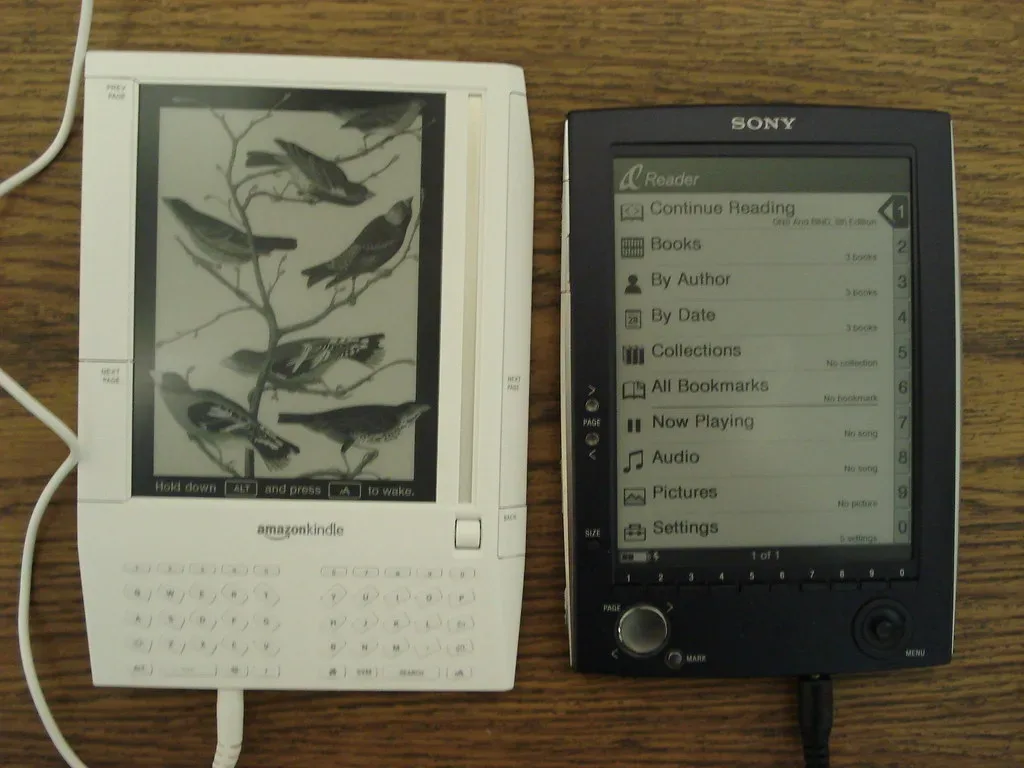 Comparativa fotografiada de un Amazon Kindle y un lector Sony Reader sobre una mesa