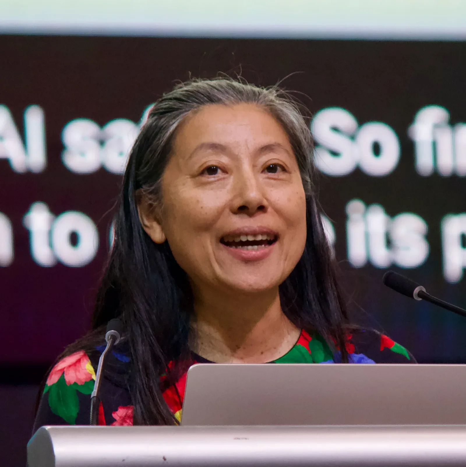 Mujer habla en un atril durante una conferencia sobre inteligencia artificial