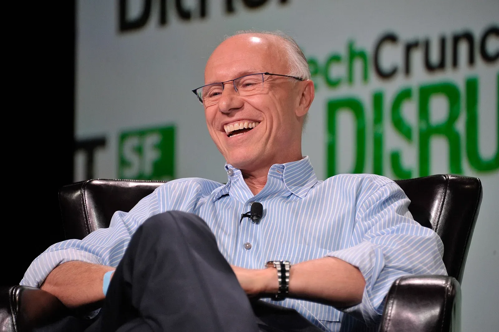 Hombre sonriente sentado en un sillón durante una entrevista en TechCrunch Disrupt