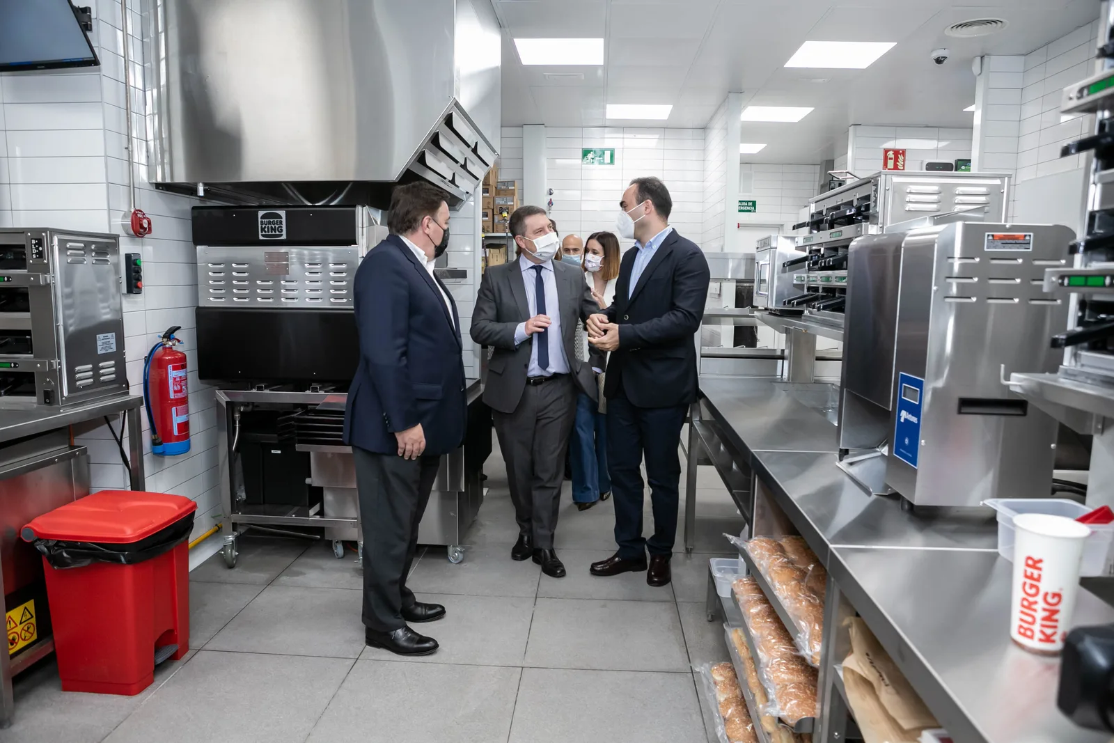 Directivos con mascarilla visitan las instalaciones de una cocina de Burger King