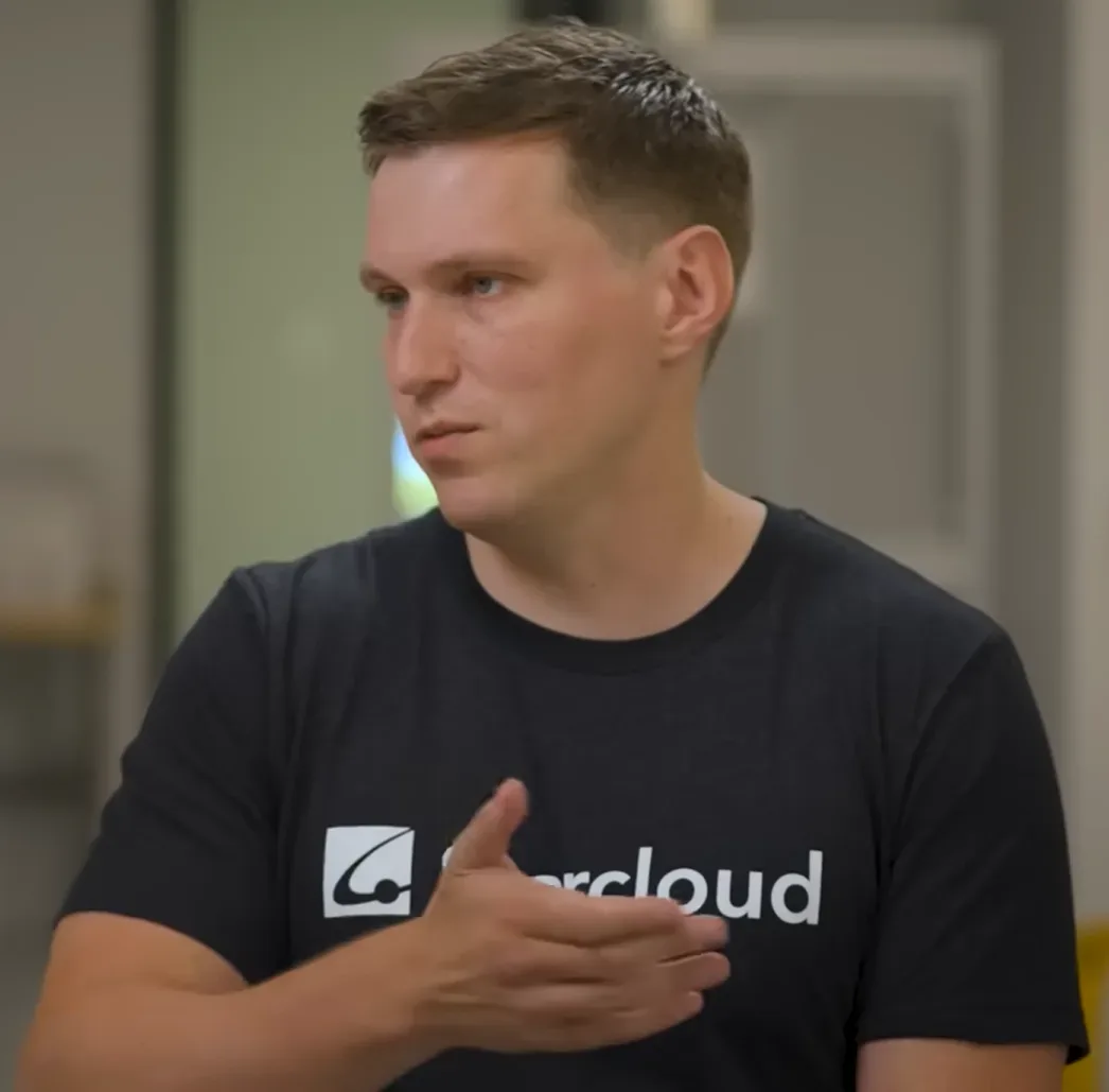Hombre con camiseta de Starcloud gesticula durante una conversación en interior