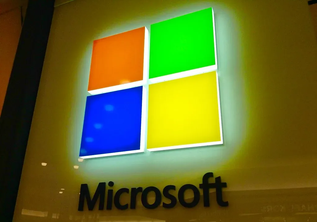 Logotipo iluminado de Microsoft en la fachada de una de sus tiendas.