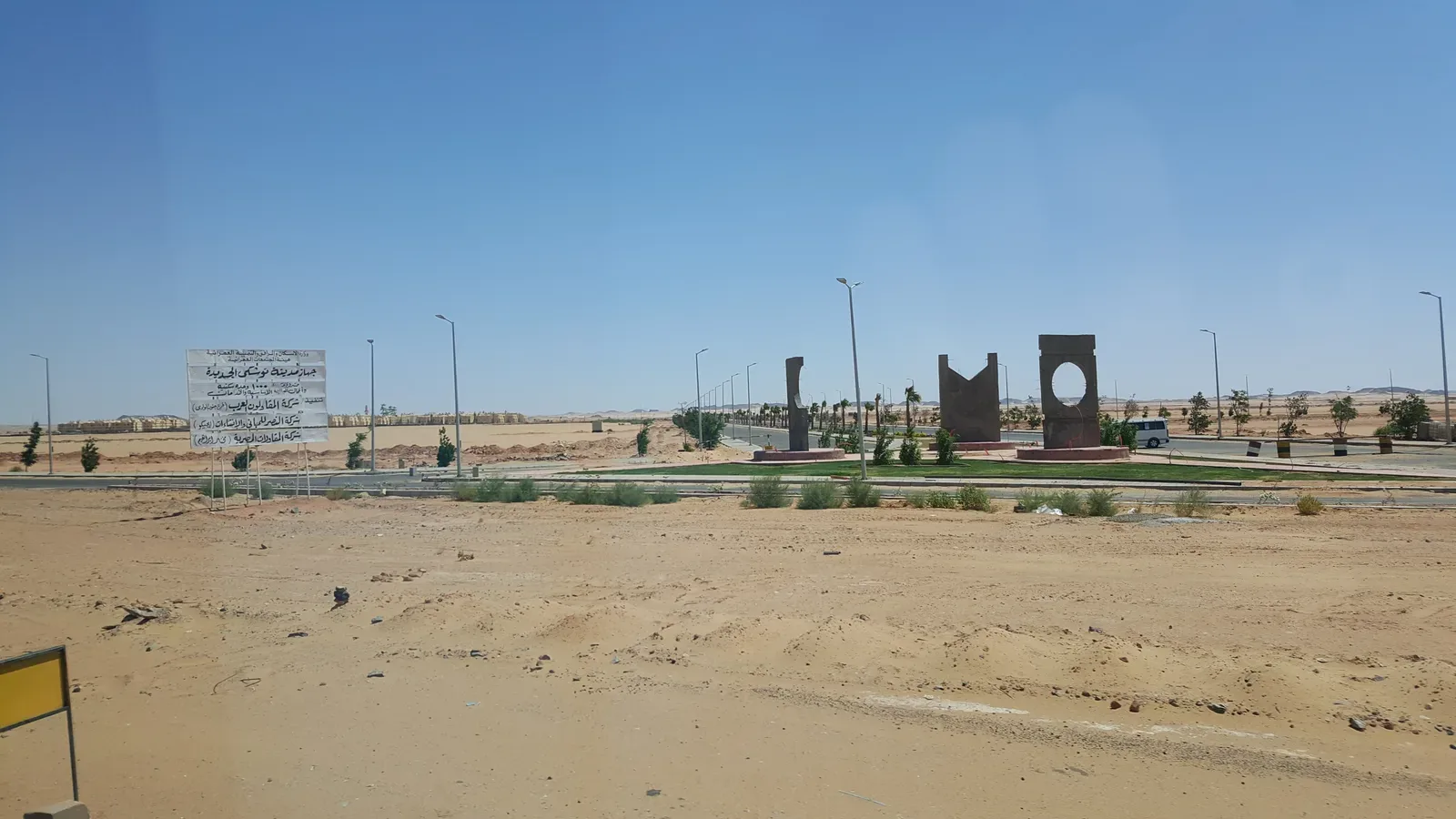 Esculturas y letrero en carretera desértica del proyecto Toshka en Egipto