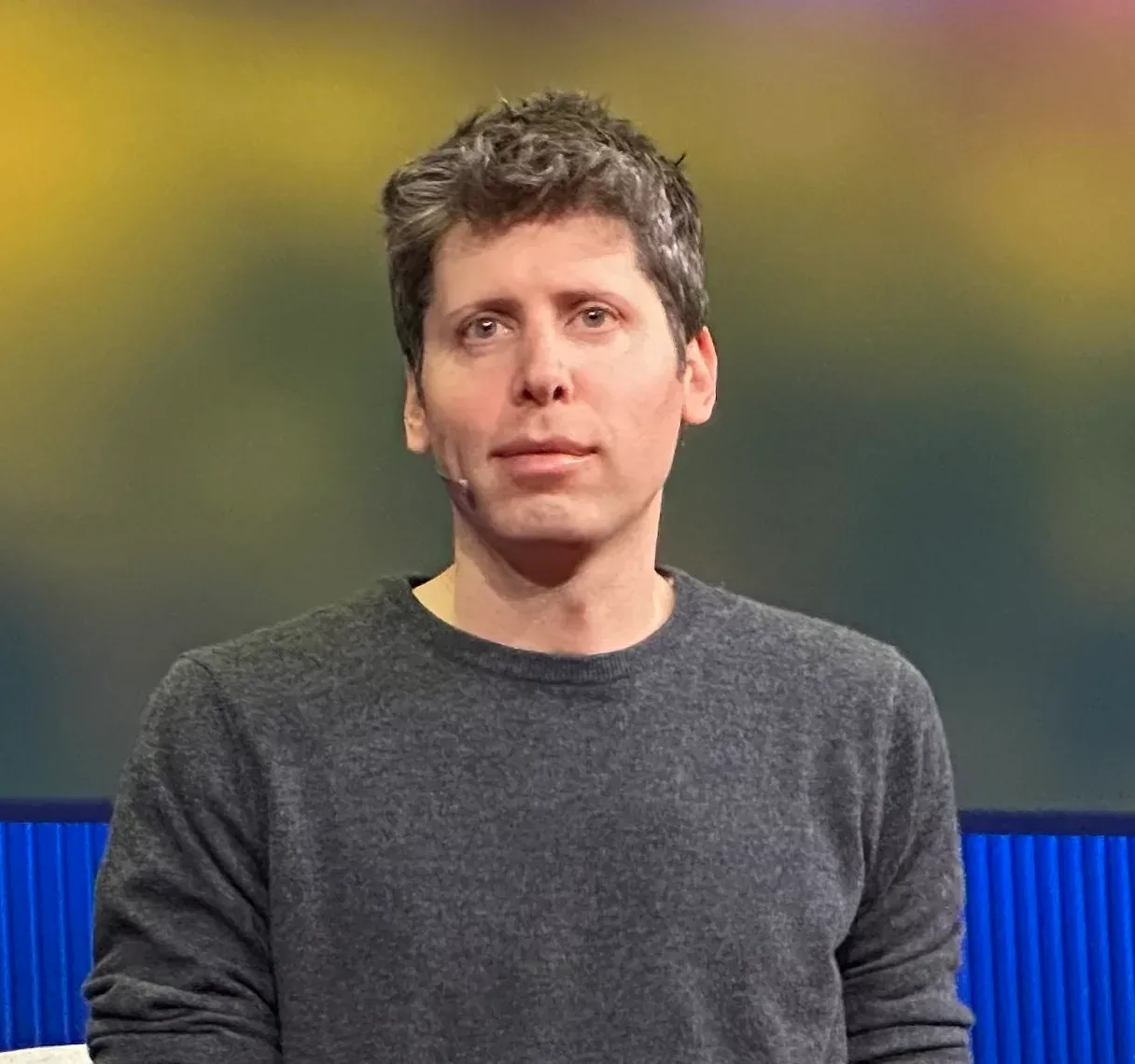 Sam Altman con micrófono de diadema durante una intervención pública en un evento