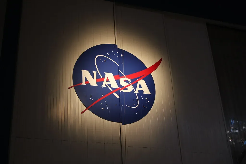 El logotipo de la NASA iluminado sobre el panel de un edificio